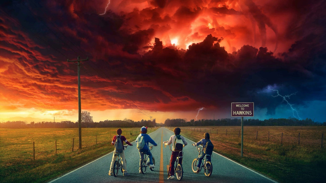 Wallpaper: four kids on bikes seen from behind on a road, the Hawkins sign and a red storm sky