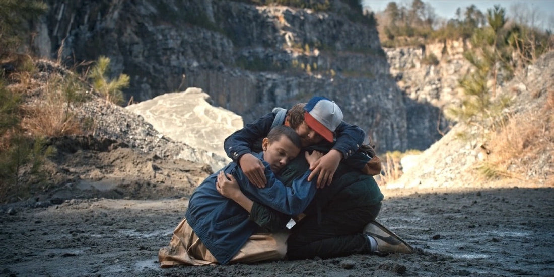 Three boys kneeling and holding each other at the bottom of a quarry, Stranger Things season 1 episode 6