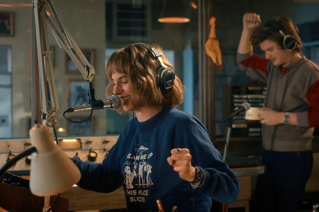 In the WSQK studio, a host in headphones sings into the mic while a boy dances behind her