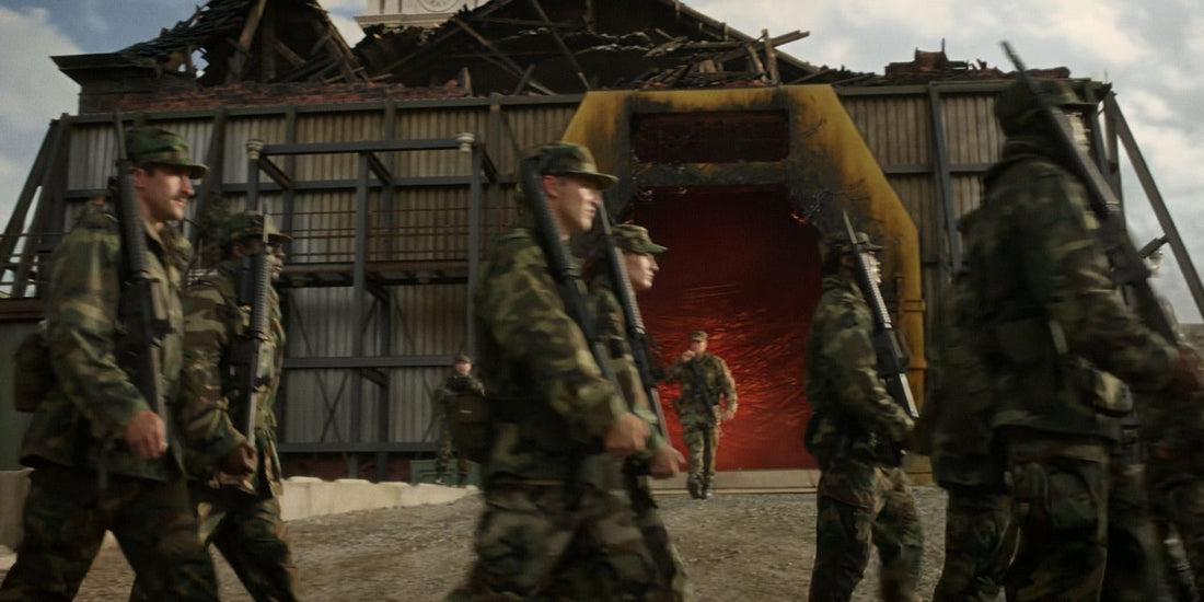 Soldiers in camouflage before a red opening, in a building with its roof torn off.