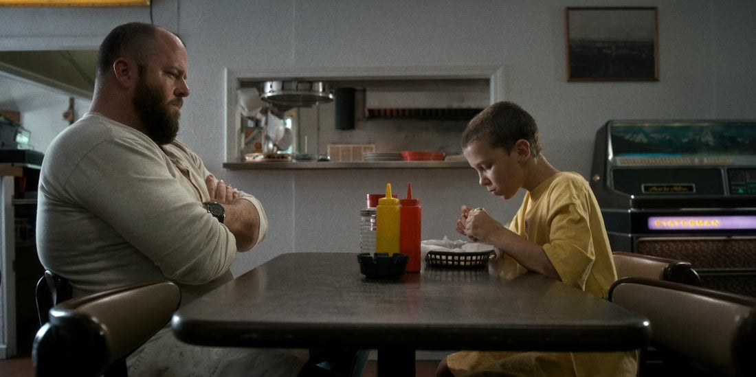 Benny Hammond watches Eleven eat at the Benny's Burgers table